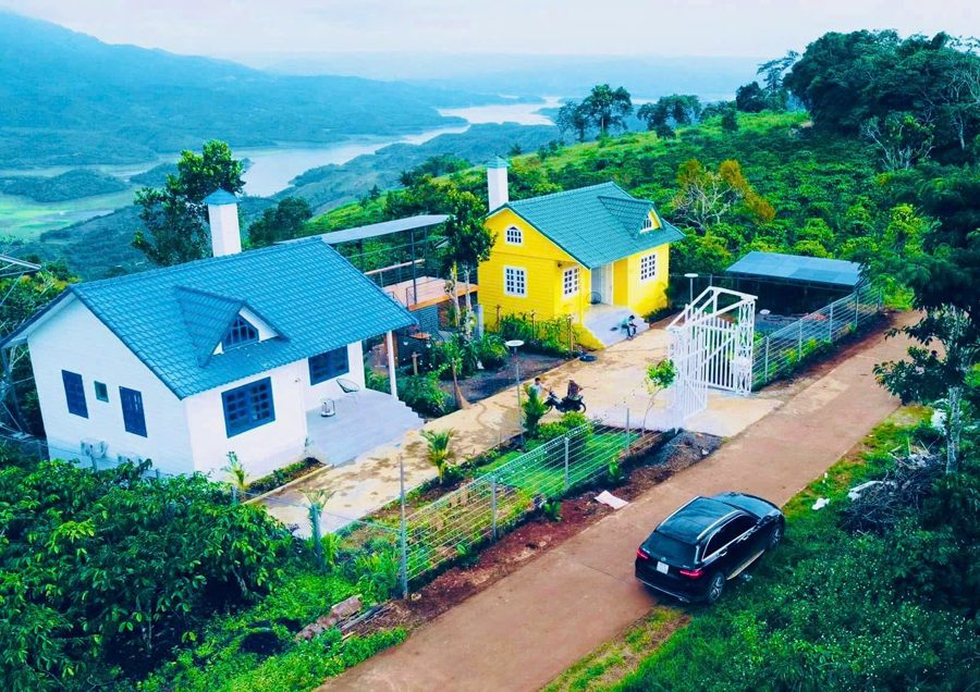 Hai căn nhà trắng và vàng trên đồi, xa xa là hồ Tà Đùng